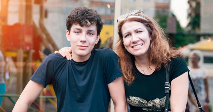A mother sits with her teen son