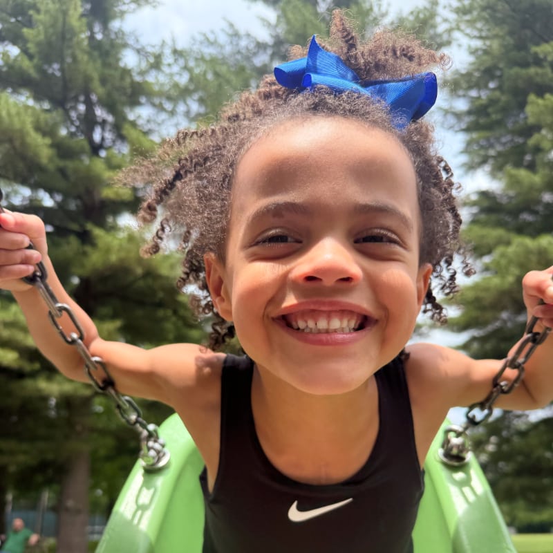 A smiling little girl on a swing
